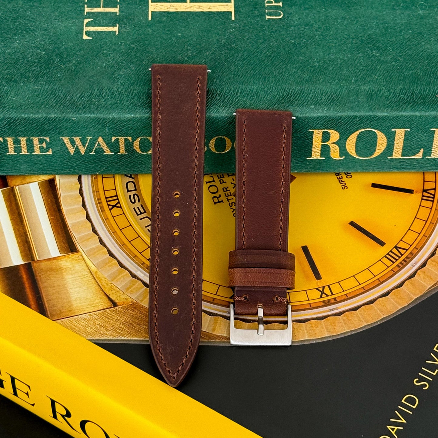 A hickory brown calf leather watch strap displayed on a surface with a focus on the texture and color of the strap.