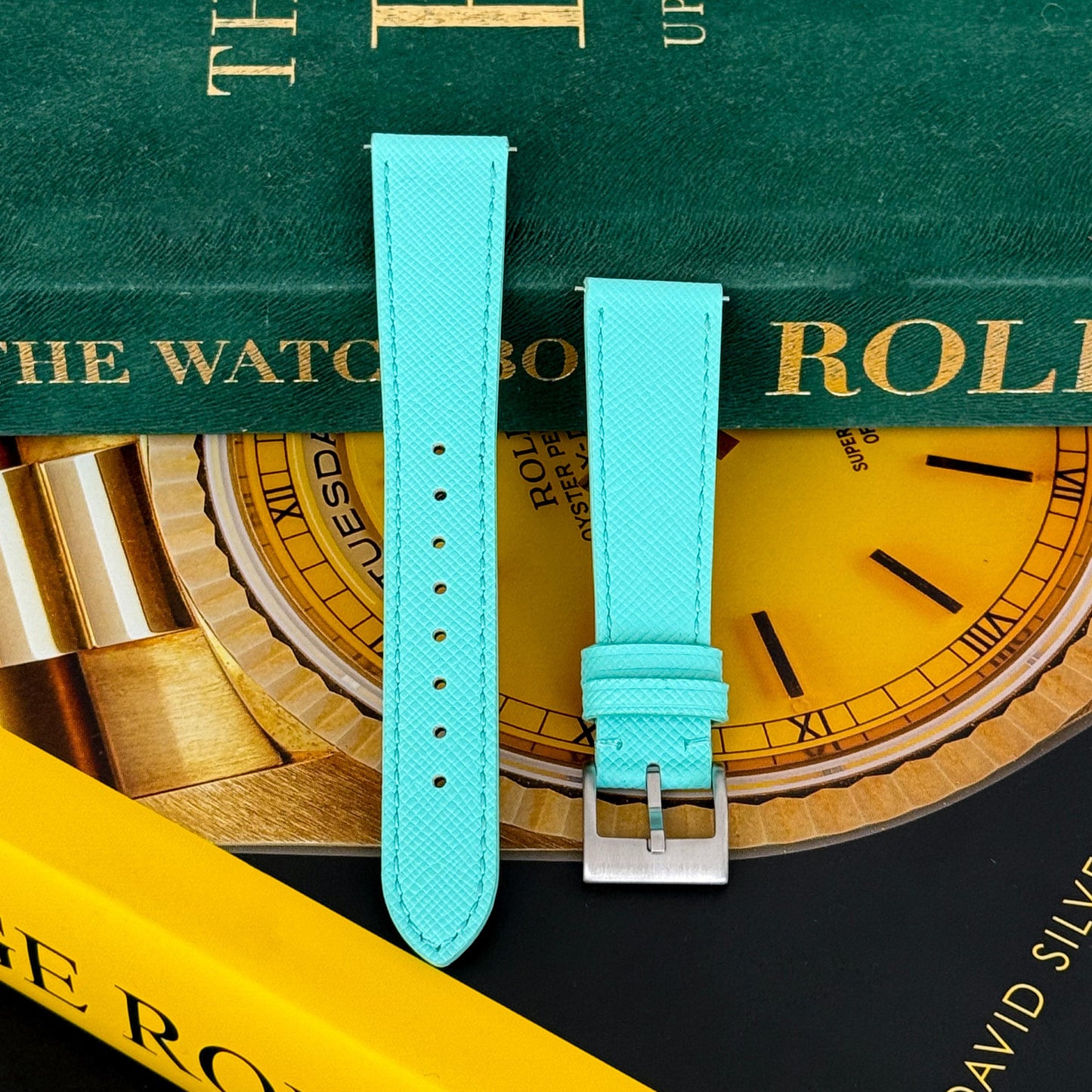 m and son leather watch strap resting on two rolex books