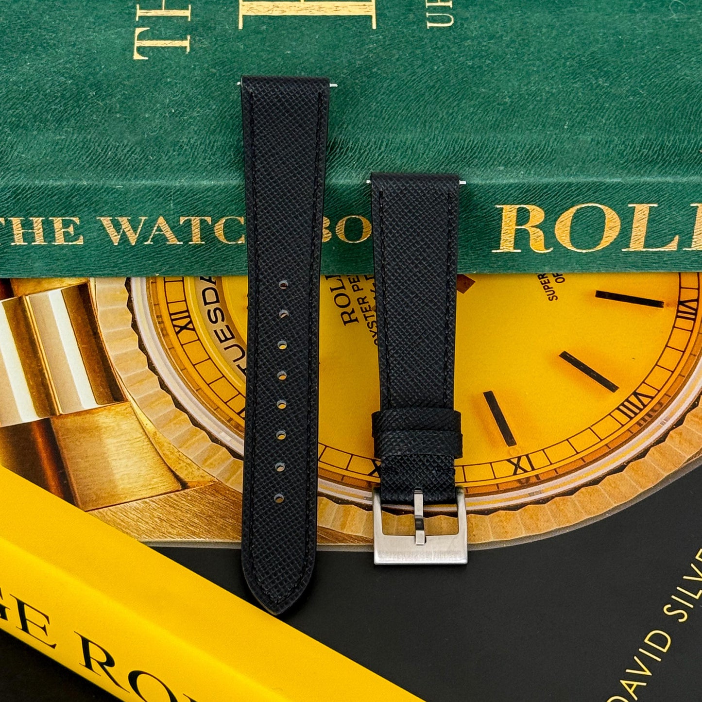 m and son leather watch strap resting on two rolex books