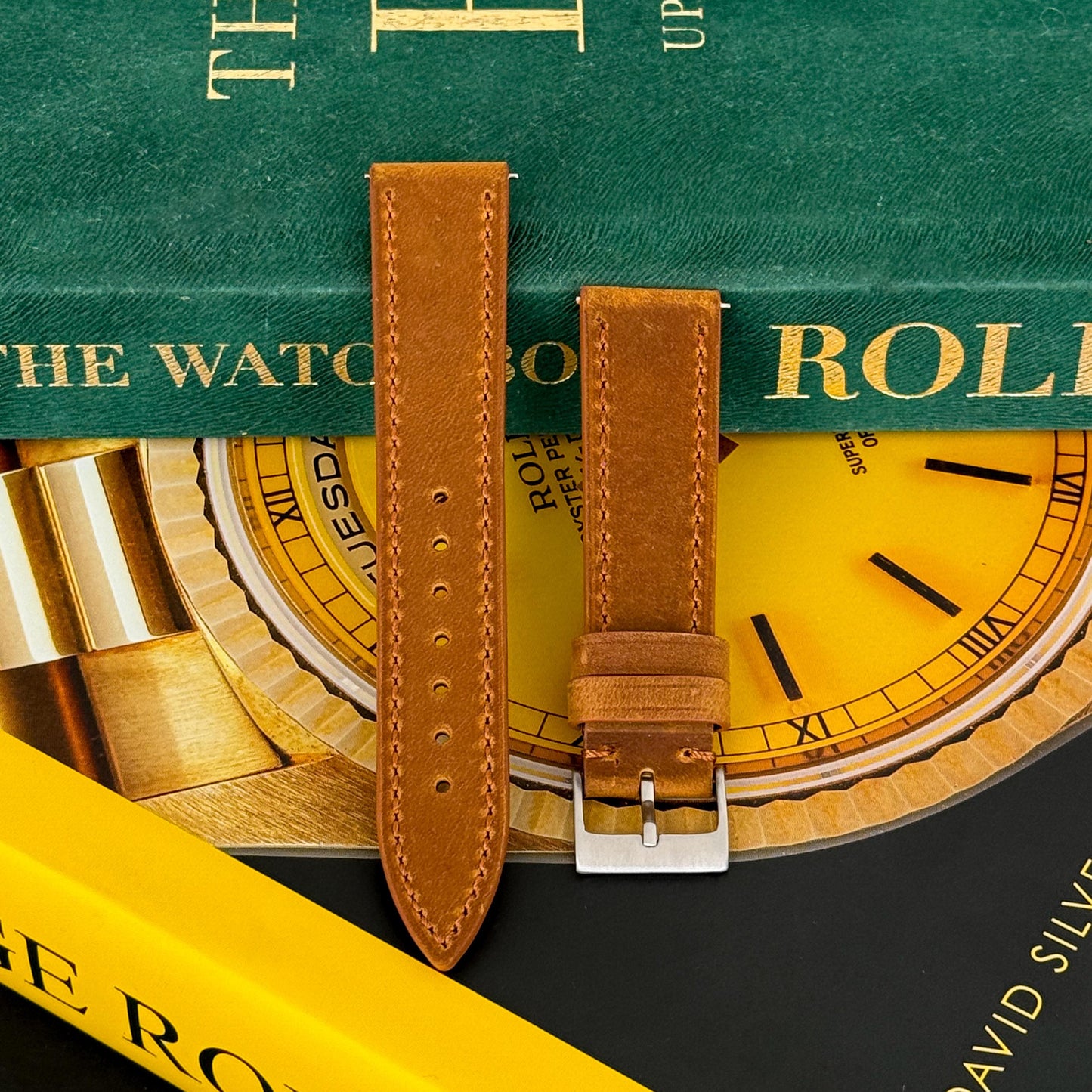 m and son leather watch strap resting on two rolex books