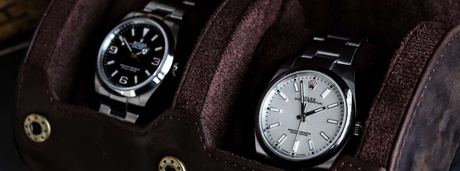 Two rolex watches displayed in a brown leather m and son watch roll