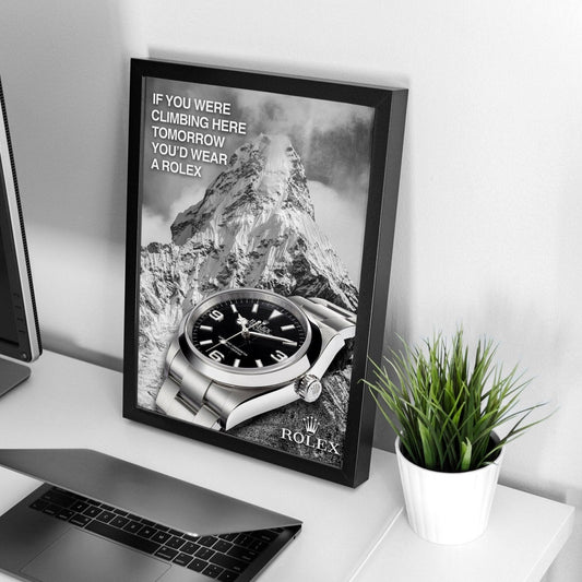 Framed Rolex Explorer watch poster displayed on a wall in a study