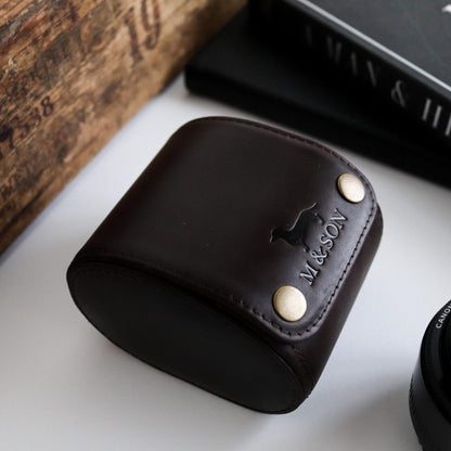 M and Son, leather watch roll with embossed logo on table, side view.