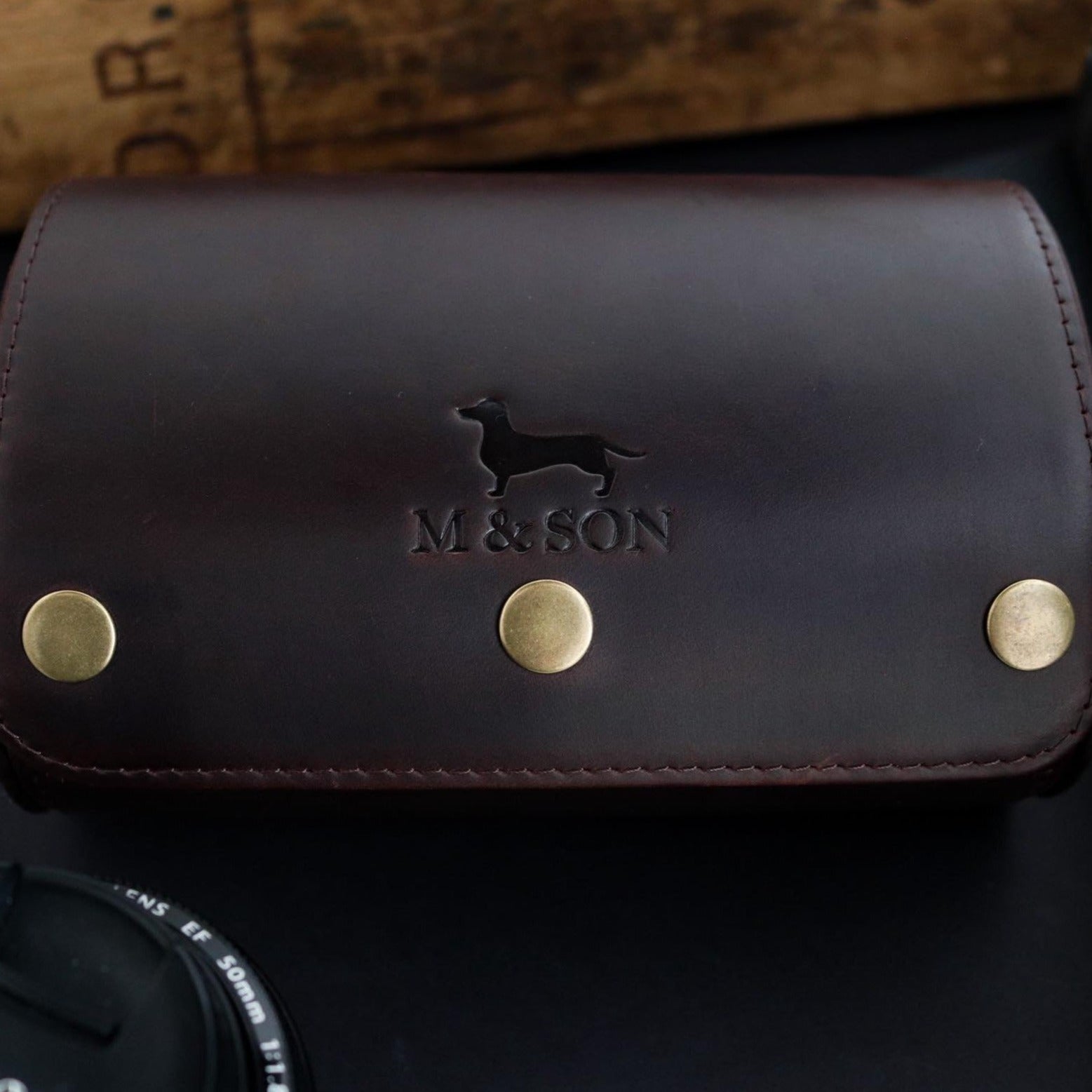 M and Son, double leather watch roll, front view of the embossed logo.