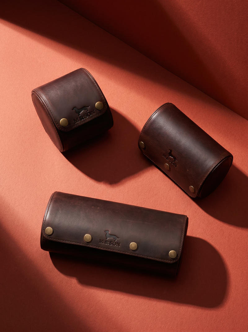Three brown leather cases with gold studs on a red background