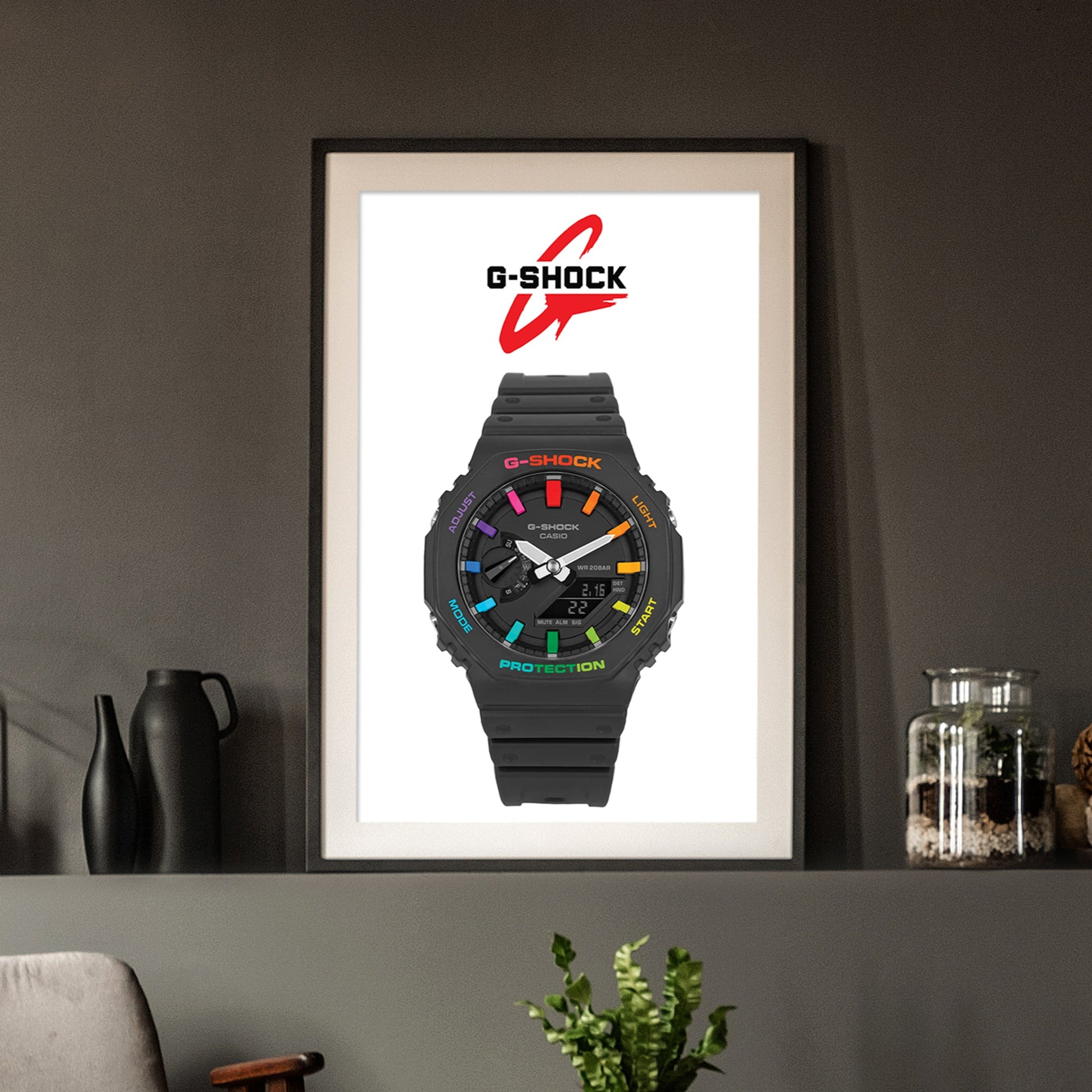Framed poster of a G-Shock watch with colorful display on a dark wall.