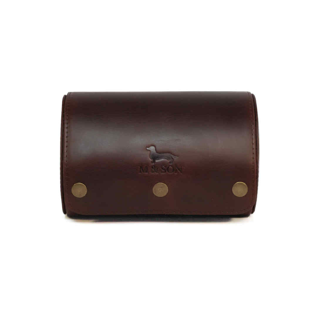 Brown leather double slot m and son branded watch roll with brass studs on a white background