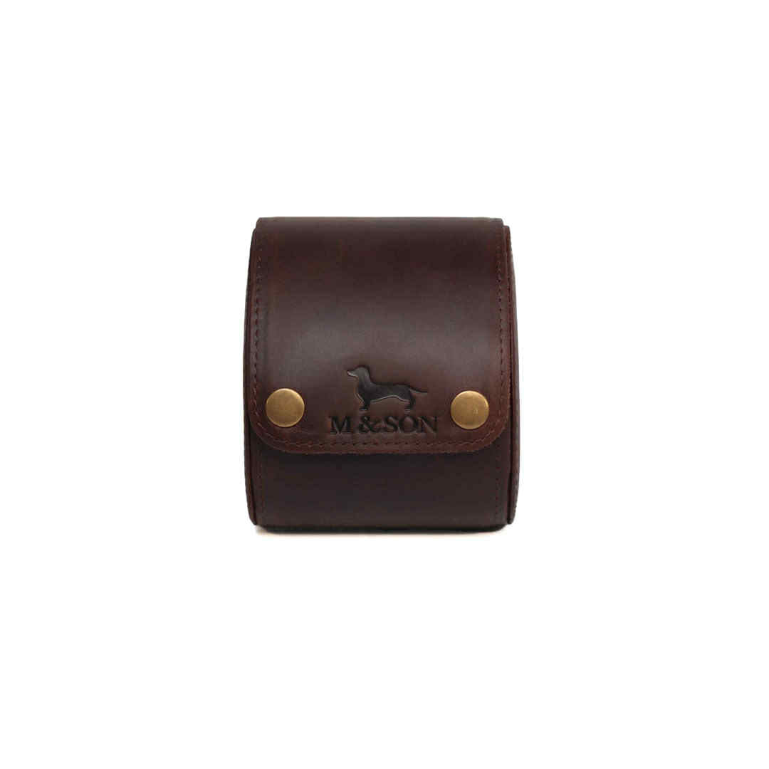 Brown leather single slot m and son branded watch roll with brass studs on a white background