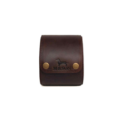 Brown leather single slot m and son branded watch roll with brass studs on a white background