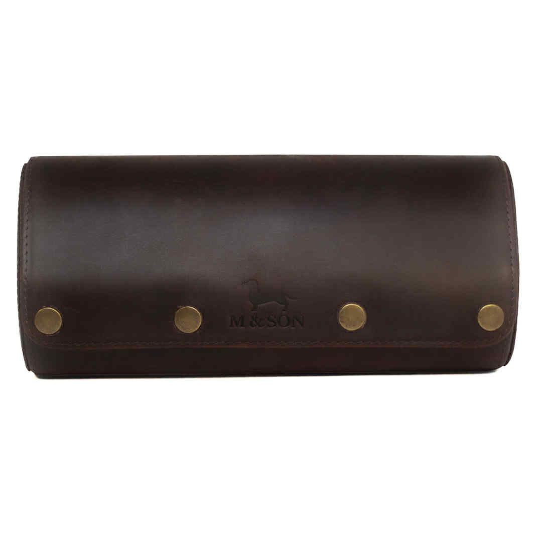 Brown leather triple slot m and son branded watch roll with brass studs on a white background