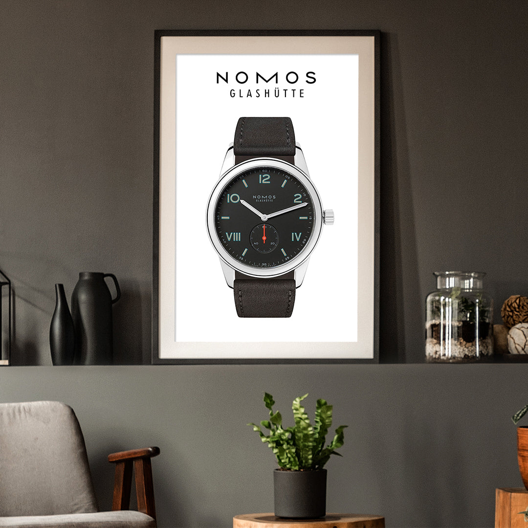 Framed poster of a Nomos Glashüte watch on a wall with decor elements.
