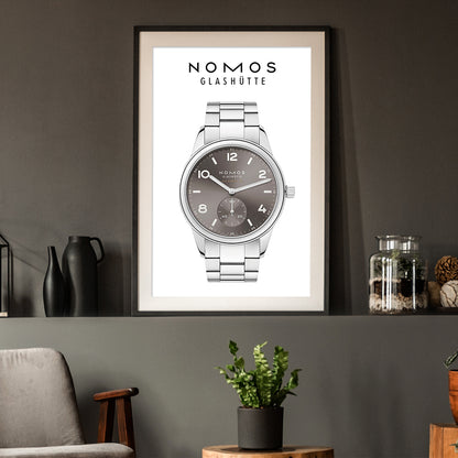Framed poster of a Nomos Glashüte watch on a wall with decorative items.